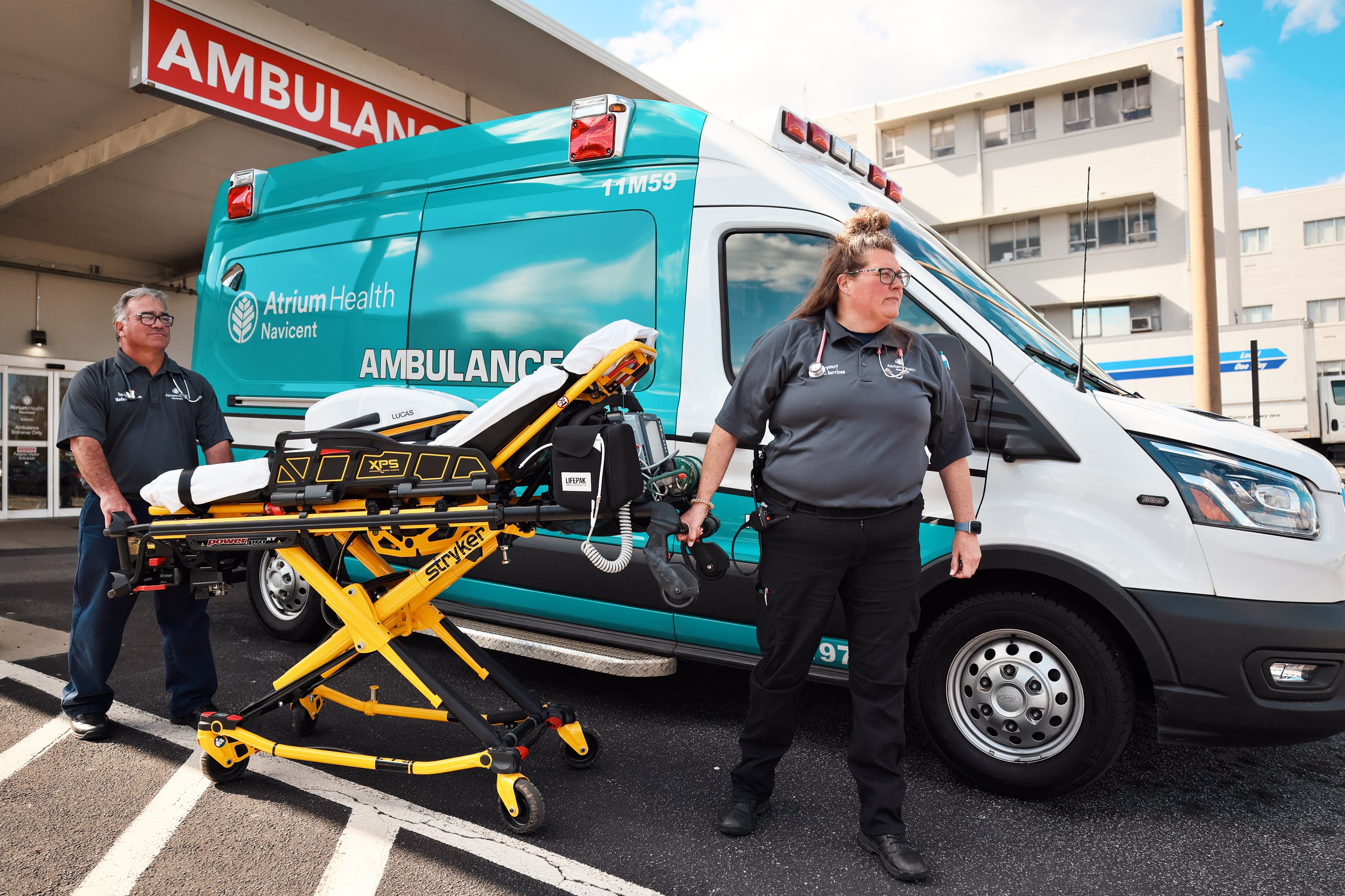 Atrium Health Navicent Emergency Medical Services, a Facility of Atrium Health Navicent The Medical Center Employees standing in front of ambulance